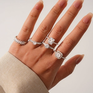 Detail view of five silver rings with square and round zircon on a model's hand