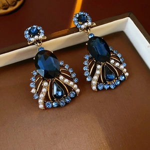 Vintage gold earrings with dark blue oval gemstones and pearls in fan-shaped design