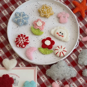 Assorted Christmas wool felt charms including stars and flowers on a white tray