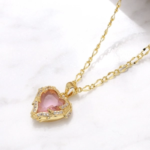 Gold plated heart pendant necklace with pink stone and zircon on marble background