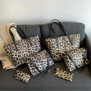 Large capacity leopard print tote bags with black straps shown on a grey fabric sofa