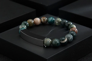 Detail of beaded bracelet with natural agate stones and curved stainless steel metal bar