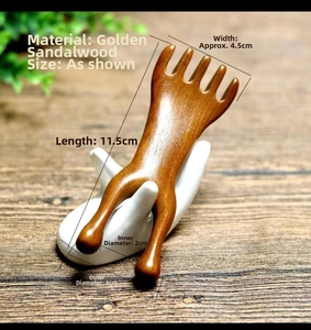 Detail view of sandalwood massage comb on ceramic display with golden wood grain texture