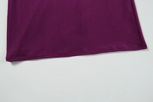 Detail of professional double-needle stitching on the hem of a purple knitted dress