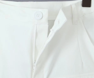 Close-up of white cargo pants featuring twill fabric texture with button and zipper detail
