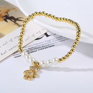 Detail view of a pearl beaded bracelet with a gold teddy bear pendant and micro-pave zircons