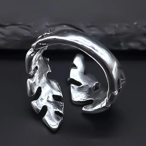 Macro shot of silver feather ring with detailed textures and open adjustable design
