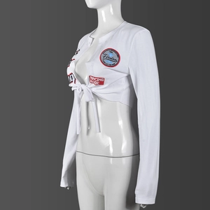 Dettaglio del crop top bianco a maniche lunghe con ricamo racing e lacci frontali