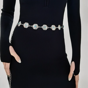 Detail of silver floral waist chain featuring turquoise stones on a model's dress