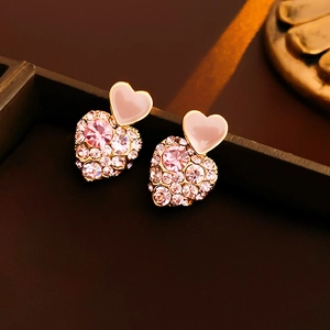 Detailed close-up of pink heart earrings with gold plating and sparkling crystals