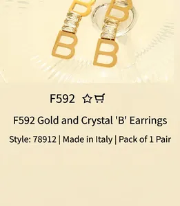 Close-up of golden B-shaped earrings inlaid with three rectangular clear zircon stones