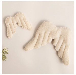 Detail of cream white wool felt angel wings set with handcrafted stitching textures