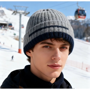 Detailed knit texture of men's winter beanie with gray and blue stripe on snow background