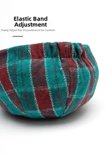 Close-up of red and green plaid beret with adjustable elastic band on white background