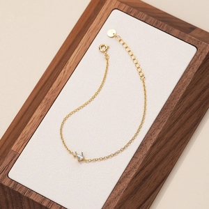 Elegant gold s925 sterling silver bracelet with sparkling zircon stones on a wooden display