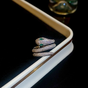 Macro shot of gold plated snake ring with emerald eyes and cubic zirconia pavé detailing