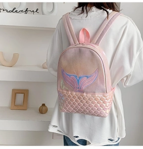 Close-up of holographic mermaid backpack with pink embroidery and fish scale pocket texture