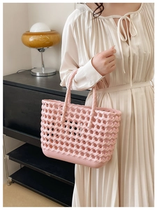 Pink woven hollow jelly basket bag held by a model for a stylish summer beach look