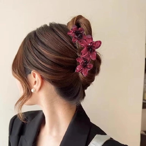 Detailed view of burgundy floral hair claw clip on elegant updo hairstyle