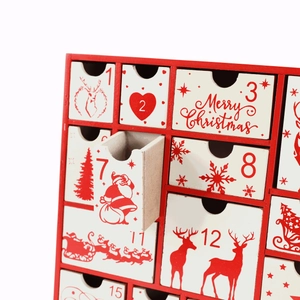 Close-up of a red and white wooden Christmas advent calendar with small pull-out drawers
