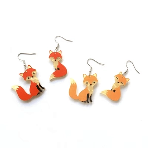 Cute orange and white asymmetric acrylic fox earrings with metal hooks on white background