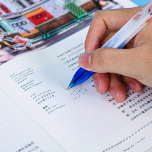 Close-up of a blue marble resin ballpoint pen writing smoothly on paper in a hand