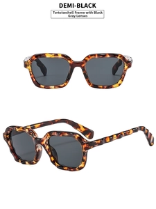 Detail of tortoise shell sunglasses with wavy frames and grey lenses in demi-black