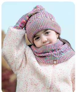 Close-up of rainbow knit winter set with soft pom-pom hat, scarf and matching gloves