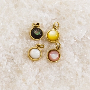 Pendentifs ronds en acier et nacre en blanc, noir, jaune et rose sur fond de cristal