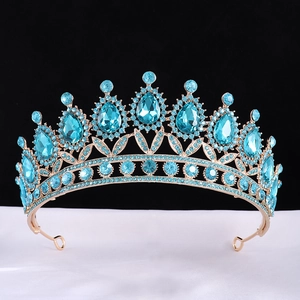 Golden baroque bridal crown with blue teardrop rhinestones on white silk background