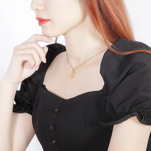 Close-up of 18k gold plated portrait pendant necklace on model with square neck top