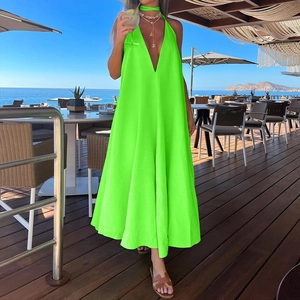 Detail of neon green V-neck halter maxi dress featuring a flowing large hem and open back design