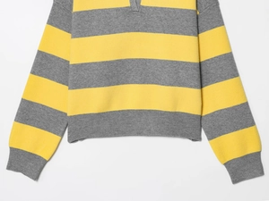 Close-up of yellow and grey striped knit texture with ribbed cuffs and hem