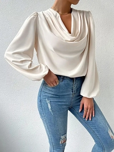 Detail of elegant beige chiffon blouse featuring a draped V-neck and smooth satin texture