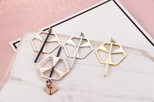 Close-up of geometric hollow hexagon earrings in rose gold, silver, and gold finish