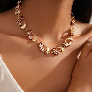Detailed view of vintage gold flower necklace with red enamel and sparkling crystals