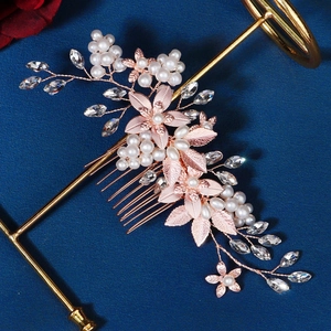 Detail of rose gold bridal hair comb with metal leaves, pearls, and crystal branches