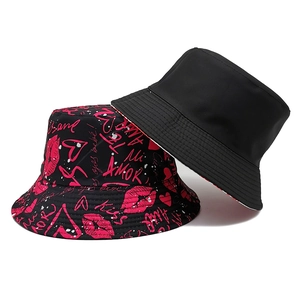 Detail of reversible bucket hat with red lip prints and solid black minimalist design