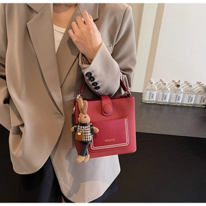 Chic red PU leather bucket bag with elegant pearl frame detail and cute bunny pendant