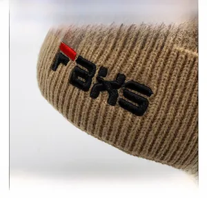 Close-up of khaki knitted beanie featuring premium black and red letter embroidery detail