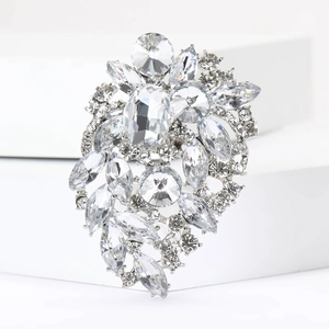 Detailed macro view of large crystal bridal brooch with marquise stones on white pedestal