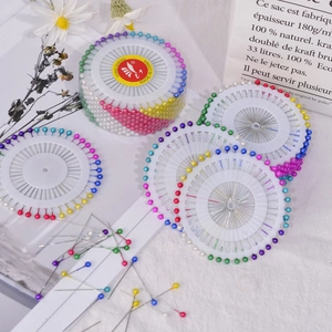 Macro view of colorful round head pearl sewing pins organized in a circular disc set