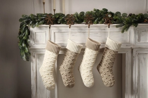 Macro detail of large knit Christmas stockings hanging on fireplace with fish scale texture