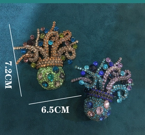 Detailed close-up of intricate crystal-encrusted octopus brooches in green and blue colors