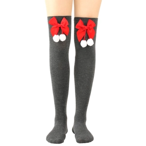 Detail of grey over-the-knee socks featuring red bows and white pom-poms on model
