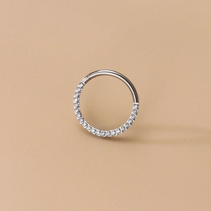 Detail of silver G23 titanium nose ring featuring half-circle cubic zirconia inlay