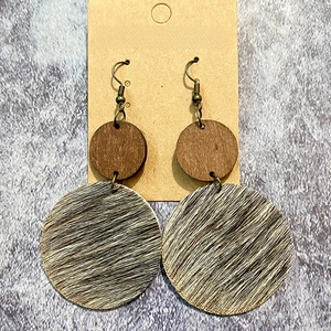 Macro detail of western retro earrings with wood and cowhide horsehair textures