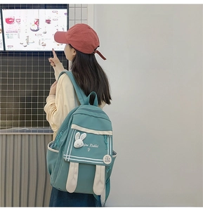 Detail of teal nylon backpack featuring cute bunny ears and custom embroidery patch