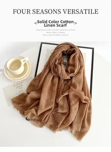 Detailed texture of dark camel cotton linen scarf with raw frayed edges and fringe