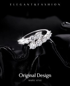 Macro shot of double-row sparkling cubic zirconia rings on black leather backdrop